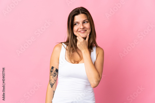 Young slovak woman isolated on pink background looking to the side and smiling