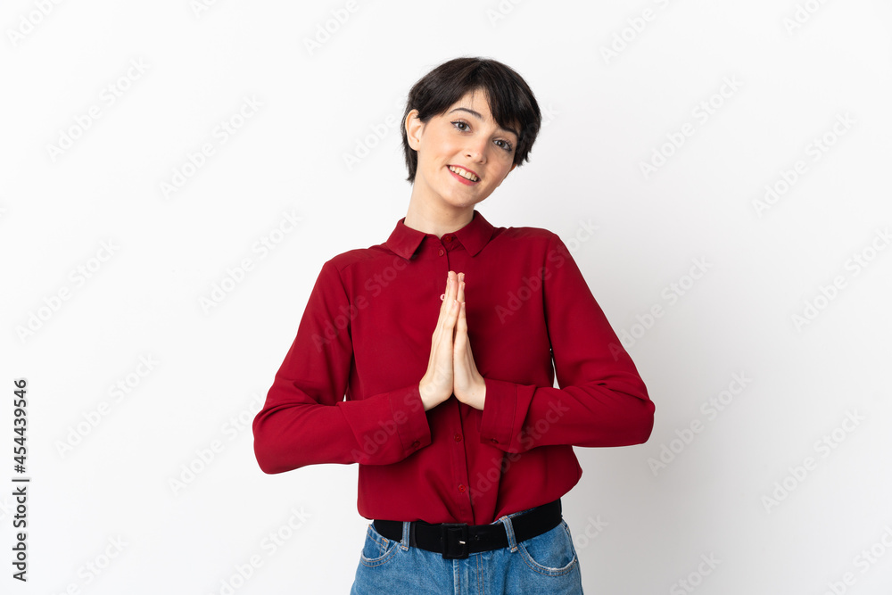 Woman with short hair isolated on white background keeps palm together. Person asks for something Woman with short hair isolated on white background keeps palm together. Person asks for something