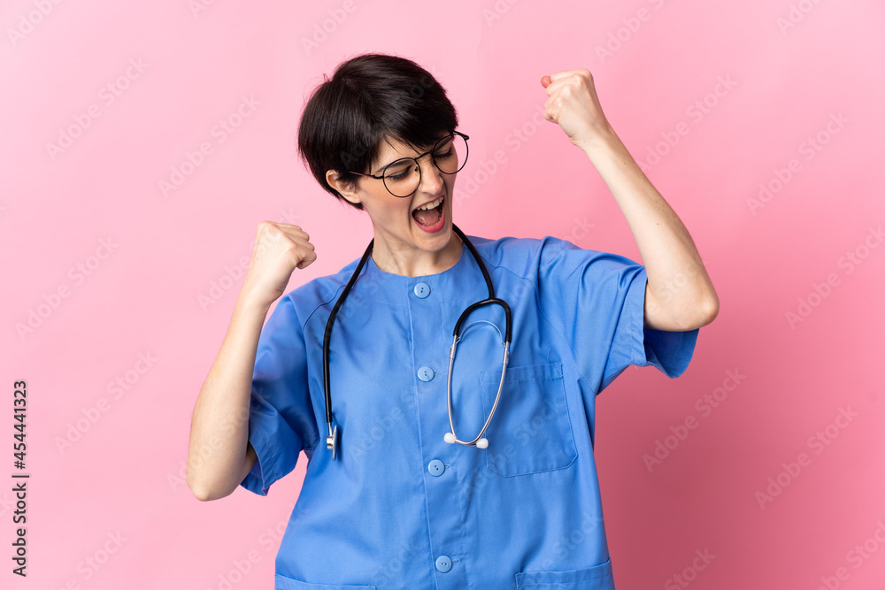 Surgeon isolated on pink background celebrating a victory Surgeon isolated on pink background celebrating a victory