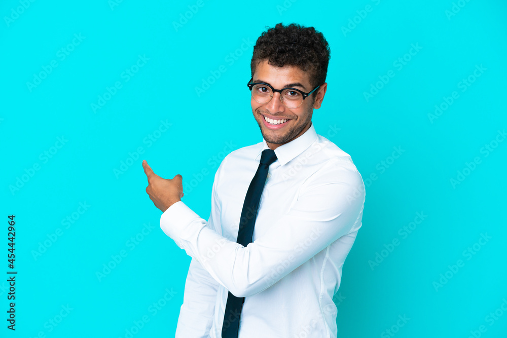 Young business Brazilian man isolated on blue background pointing back Young business Brazilian man isolated on blue background pointing back