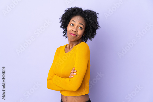 Young African American woman isolated on purple background making doubts gesture while lifting the shoulders