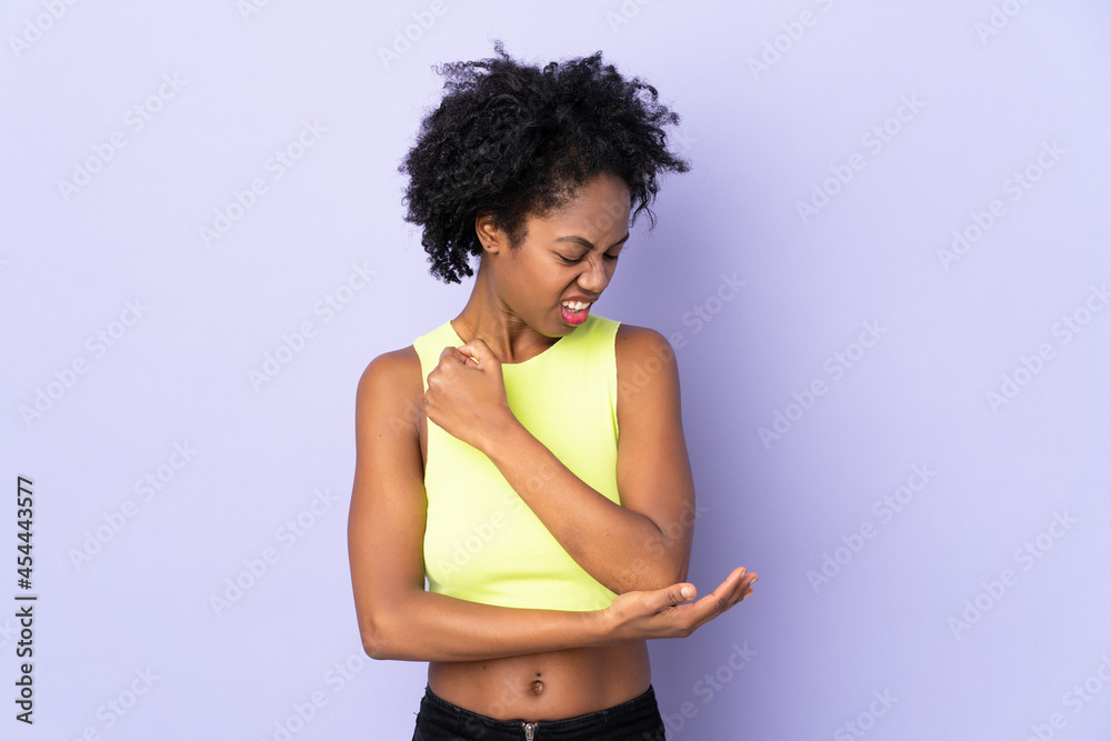 Young African American woman isolated on purple background with pain in elbow Young African American woman isolated on purple background with pain in elbow