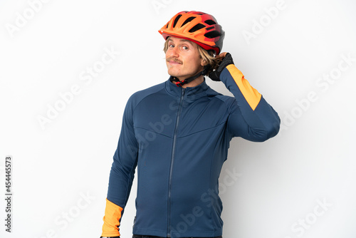 Young blonde cyclist man isolated on white background having doubts