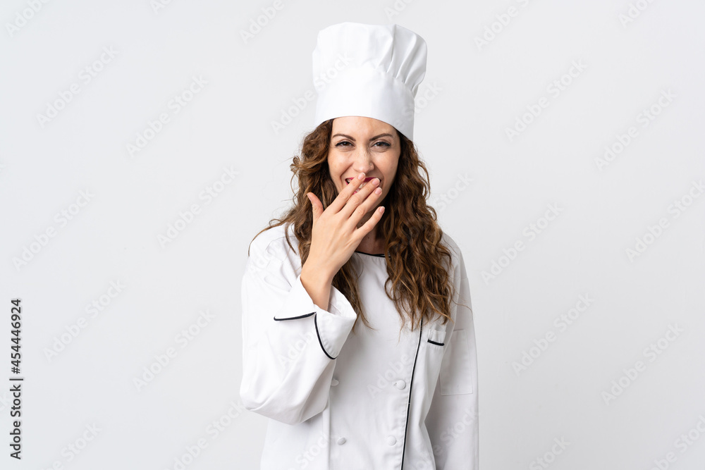 Young chef woman isolated on white background happy and smiling covering mouth with hand Young chef woman isolated on white background happy and smiling covering mouth with hand