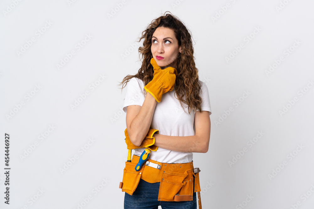 Young electrician man isolated on white background having doubts Young electrician man isolated on white background having doubts