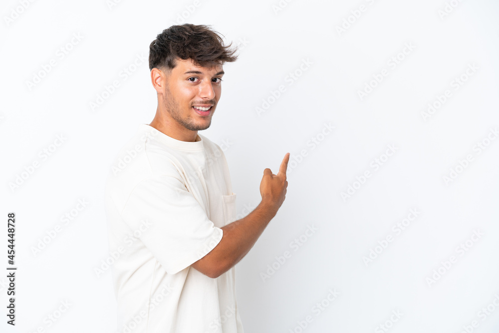 Young caucasian handsome man isolated on white background pointing back Young caucasian handsome man isolated on white background pointing back