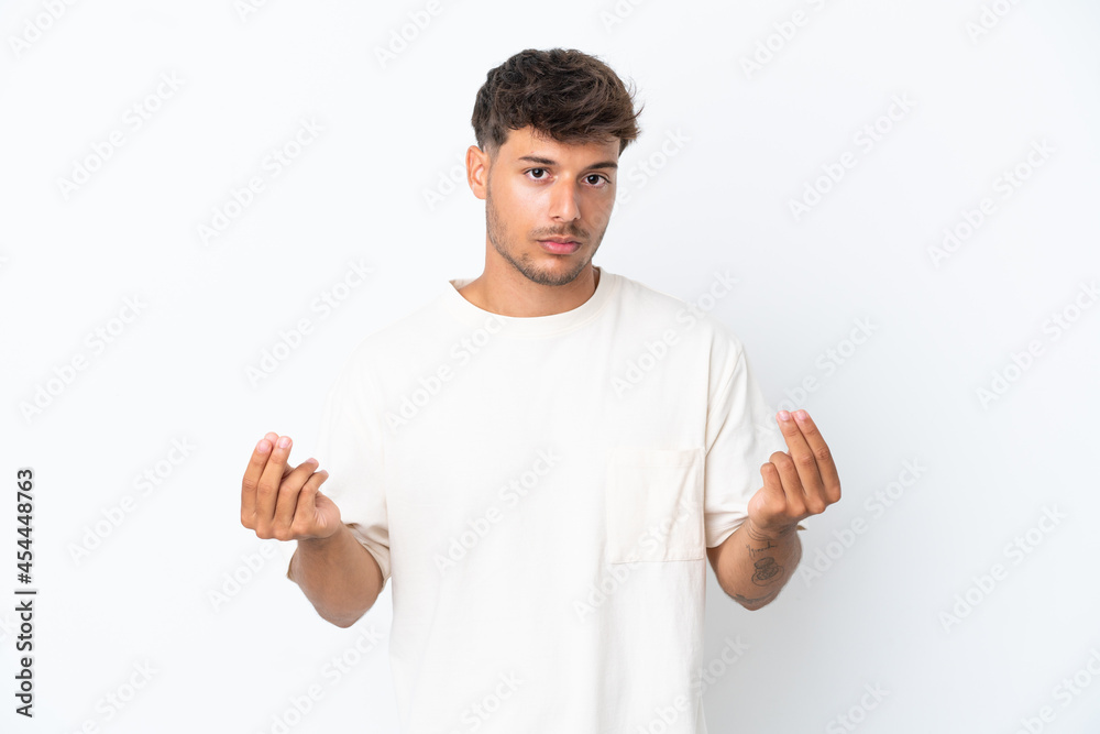 Young caucasian handsome man isolated on white background making money gesture but is ruined Young caucasian handsome man isolated on white background making money gesture but is ruined