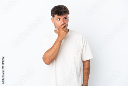 Young caucasian handsome man isolated on white background having doubts and with confuse face expression