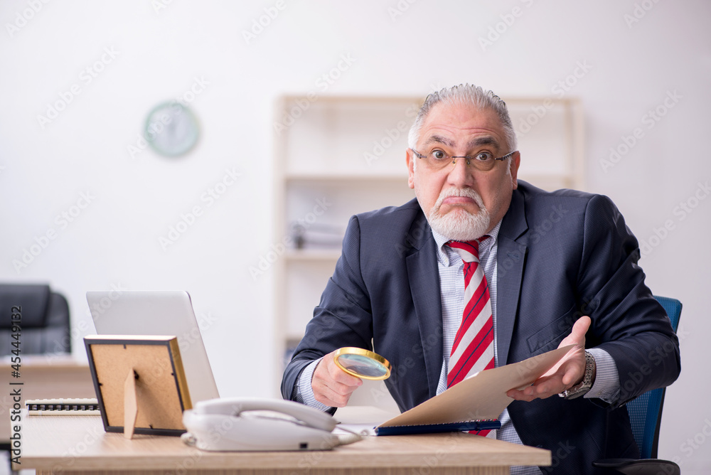 Old male employee working in the office Old male employee working in the office