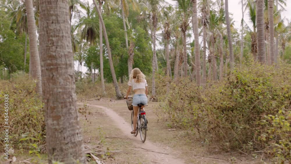 woman riding bicycle exploring tropical island girl on bike enjoying beautiful palm tree forest 4k woman riding bicycle exploring tropical island girl on bike enjoying beautiful palm tree forest 4k