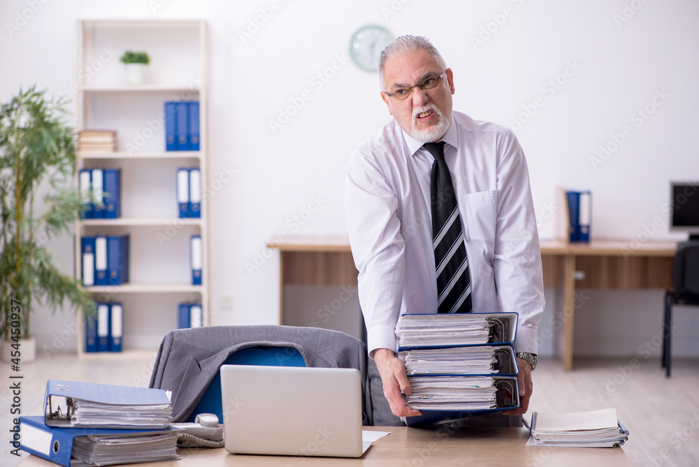 Old male employee unhappy with excessive work in the office