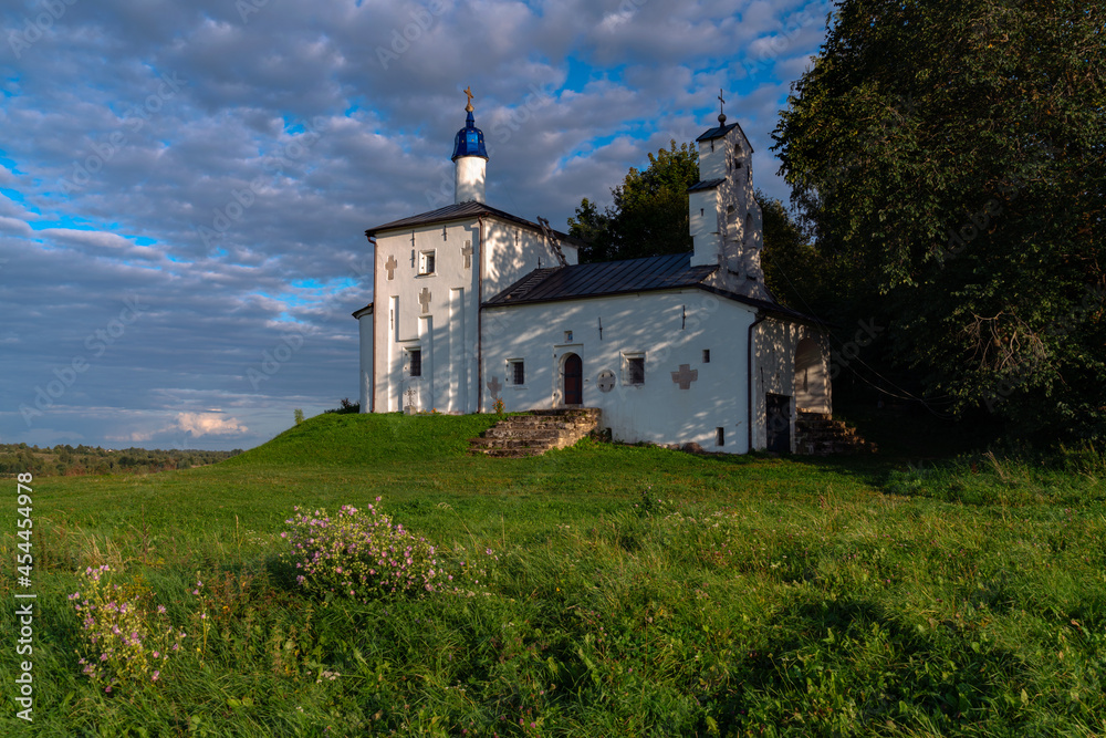 Saint Nicholas Church in Gorodishche  (Nikolskaya church) on Truvorov Gorodishche on a sunny summer evening with clouds. Stary Izborsk, Pskov region, Russia