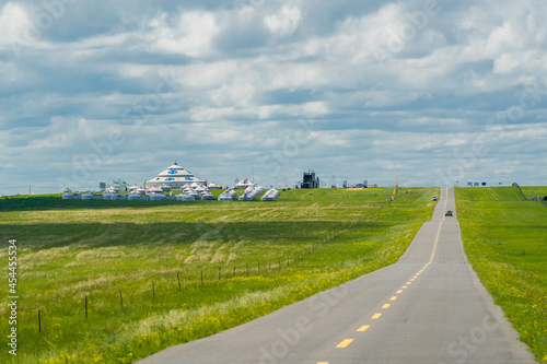 A road on green grassland during summer time.