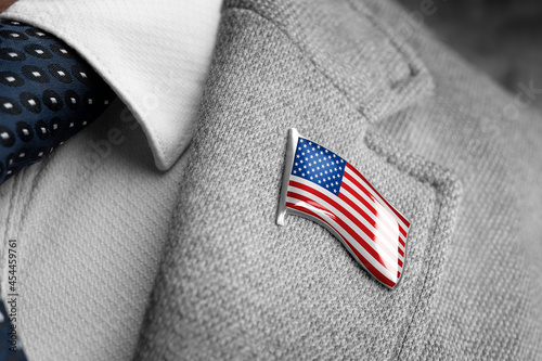 Metal badge with the flag of USA on a suit lapel photo
