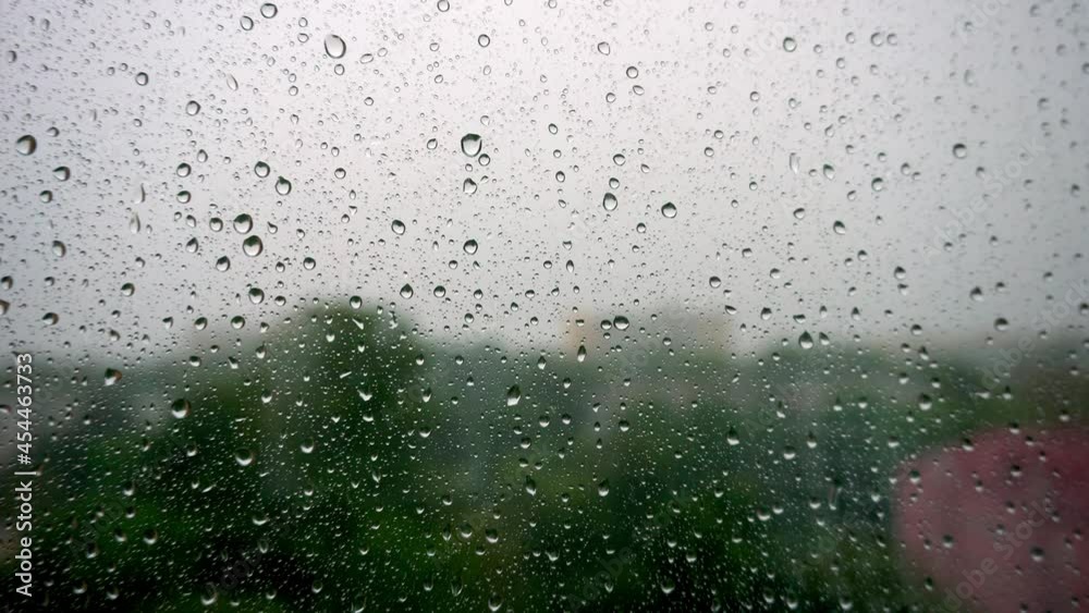 Drops of water from the rain flow down the glass, raindrops on window