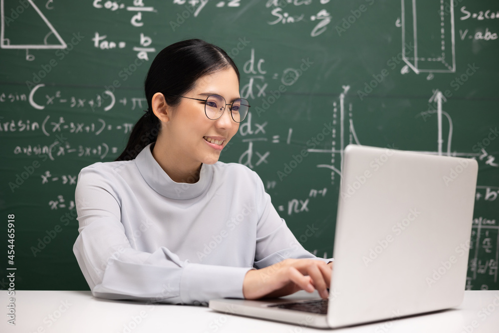 Young asian teacher woman sitting using laptop video conference with student. Female teacher training the mathematics in classroom from live stream with computer online course. Young asian teacher woman sitting using laptop video conference with student. Female teacher training the mathematics in classroom from live stream with computer online course.