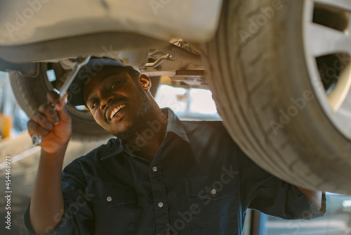 African maintenance male checking car with use wrench , service via insurance system at Auomobile repair and check up center photo