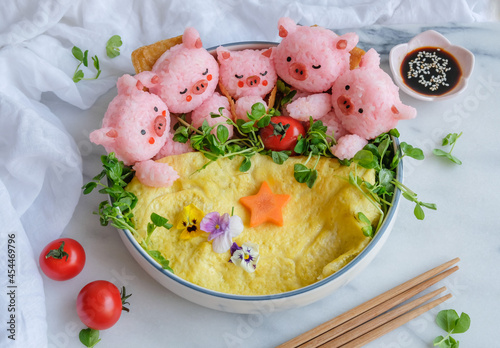 Delicious homemade Japanese cuisine. Sleeping Animated Shaped Onigiri with Omelette, Pea Sprout & Edible Flowers. Healthy, fun and joy to make with family members.  photo