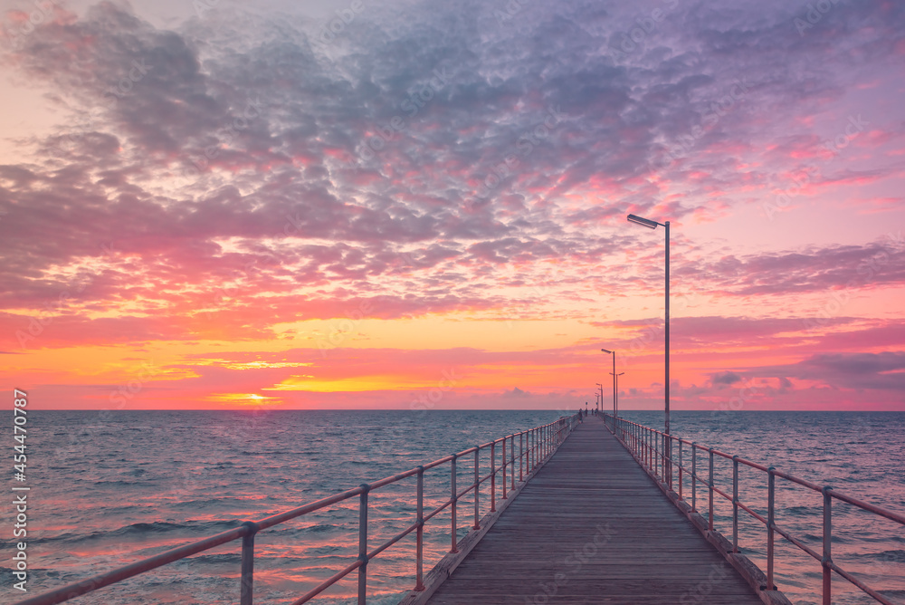 Port Noarlunga jetty with people during pink sunset, South Australia