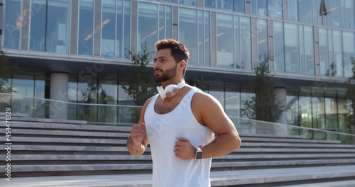 Indian athletic man jogging outdoors near business center photo