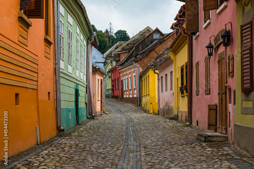 ルーマニア　トランシルヴァニア地方のシギショアラの歴史地区の町並み　カラフルな家と石畳の路地 © pespiero
