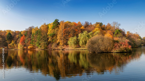 Autumn landscape. Autumn trees with colorful leaves reflection in the lake. 