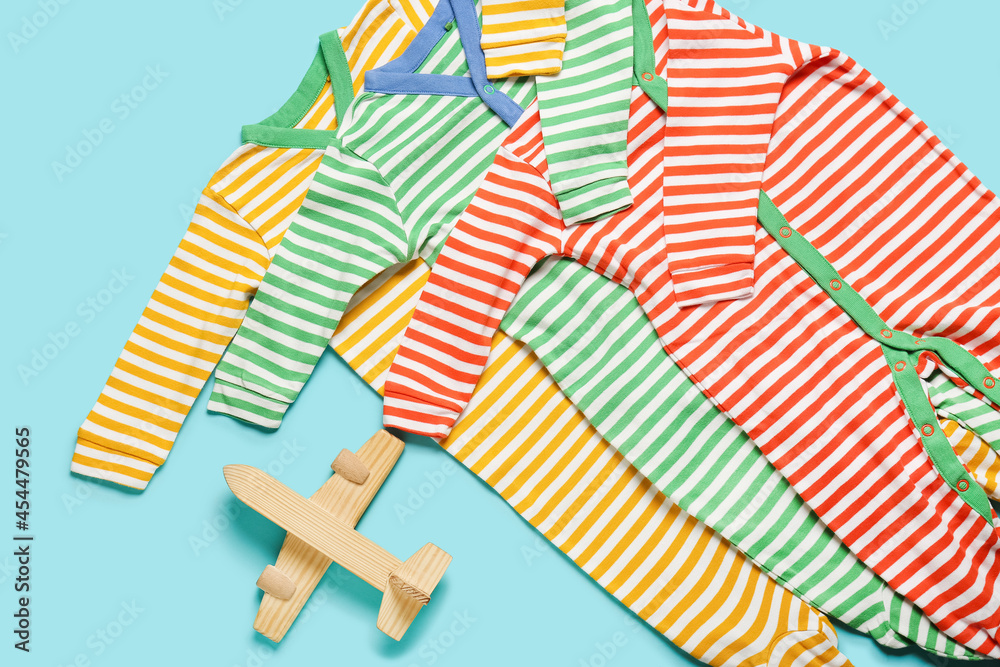 Fototapeta premium Stylish baby clothes with toy on color background