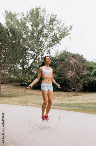 Chinese woman skipping rope outside at park