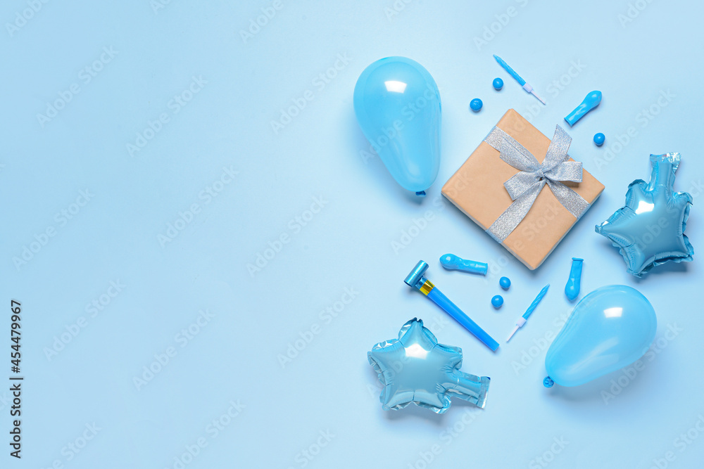 Gift box, balloons, noisemaker and candles on color background Gift box, balloons, noisemaker and candles on color background
