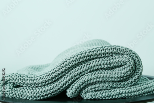 Knitted plaid on color background, closeup