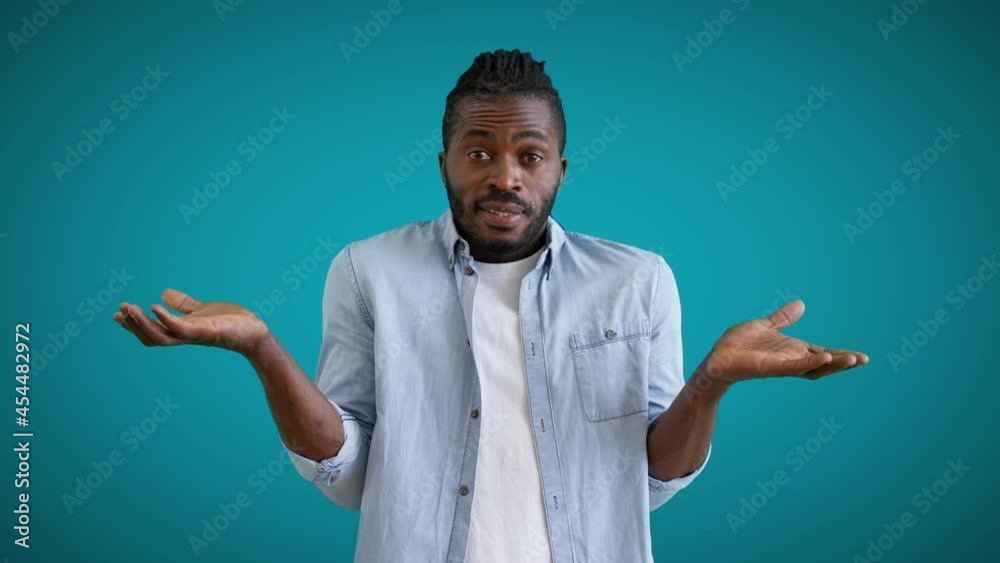 Young male with afro hair showing no idea gesture, feeling confused, doubt