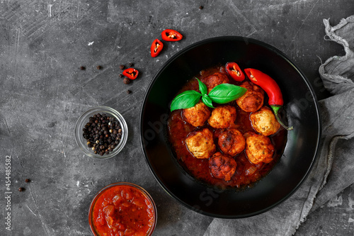 Chicken meatballs with basil and tomato sauce. Dark background. Copyspace. Meatballs with tomato and chili. Top view