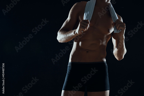 man with muscular abs cropped view of gym dark background