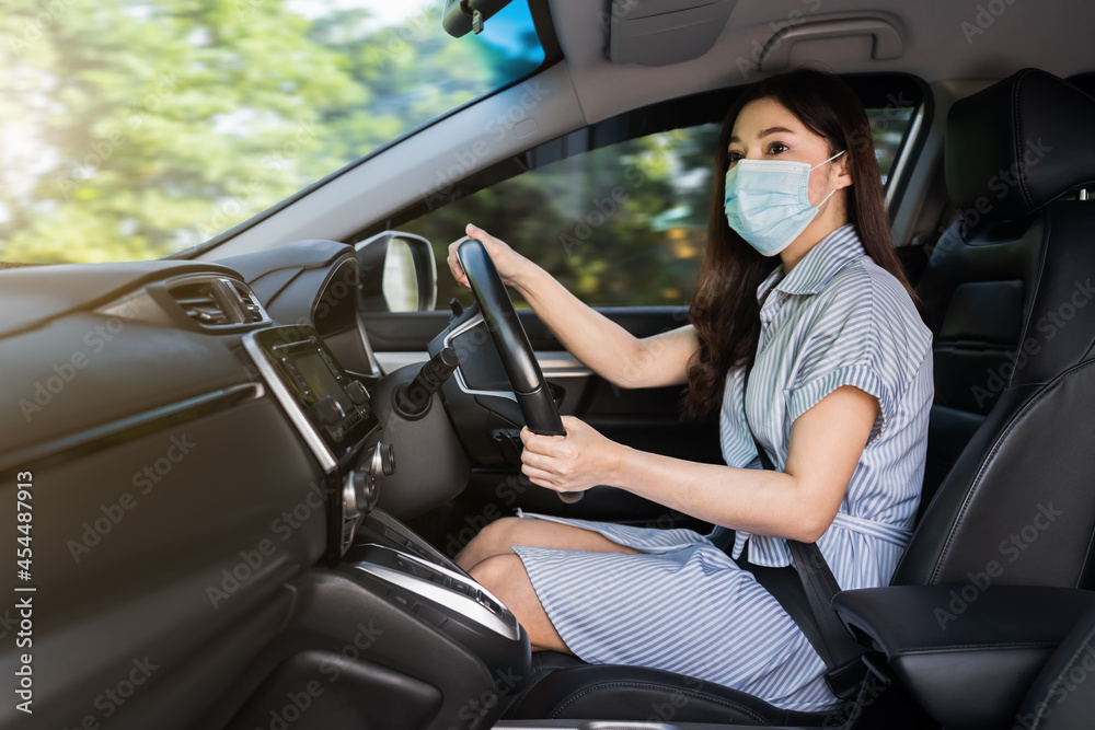woman in medical mask driving a car. for protect covid-19 (coronavirus) pandemic