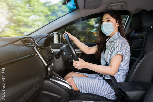 woman in medical mask driving a car. for protect covid-19 (coronavirus) pandemic © geargodz