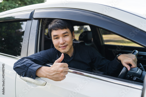 man giving thumb up inside his car