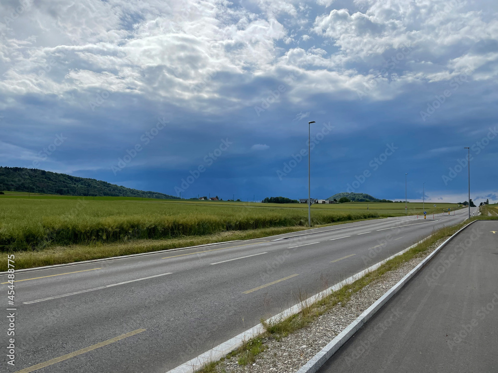 Deserted road with the leaden clouds of an approaching thunderstorm on the horizon