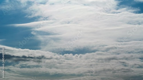 White clouds floating on blue sky like wave. Airplanes flying across sky scape. Time lapse at sunny day. Awesome cloudscape in summer.