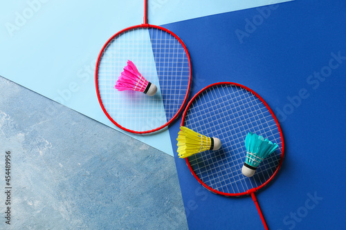 Badminton rackets and shuttlecocks on color background © Pixel-Shot