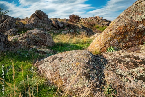 A small pile of stones in a green-yellow field against the background of a sky in Ukraine