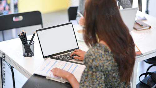Konstfotografi Professional businesswoman working with insurance report and typing on laptop