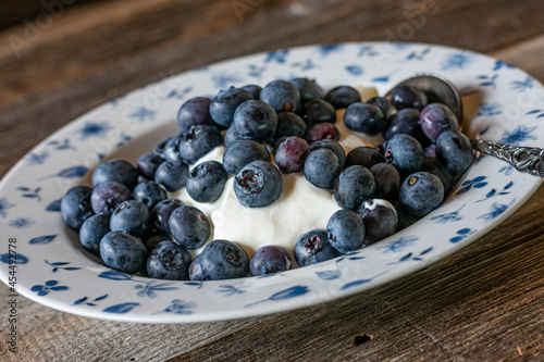 Skyr with fresh blueberries isolated on wooden table