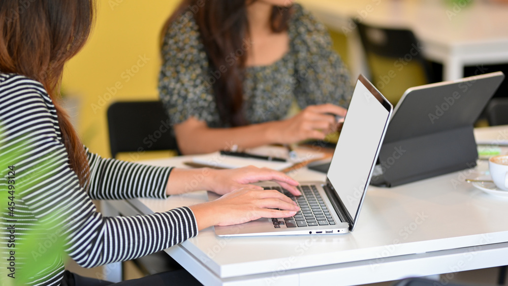 Business female worker works on laptop and digital tablet in office room Business female worker works on laptop and digital tablet in office room