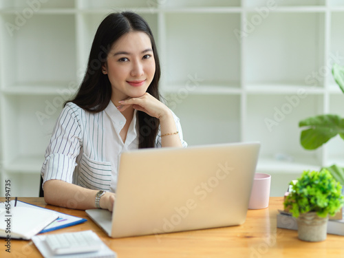 Beautiful asian businesswoman positive smile to camera, hand on chin