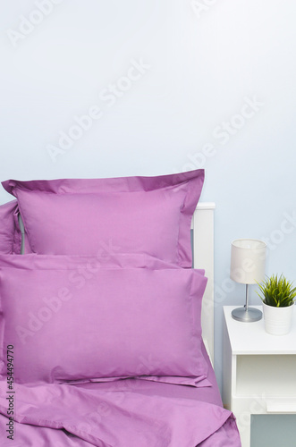 Bed in the hotel covered with purple linens