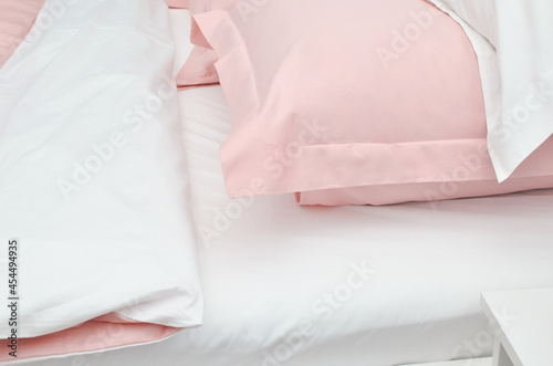 Bed in the hotel covered with pink linens
