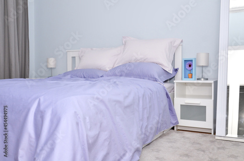 Bed in the hotel covered with blue linens
