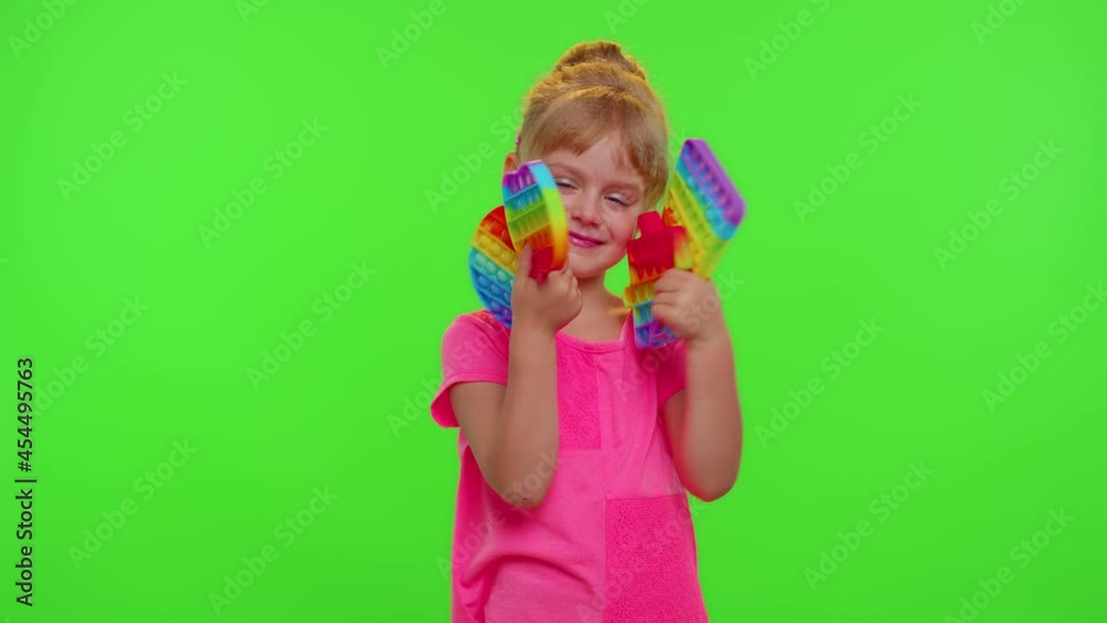 Girl hiding behind many pop it sensory anti-stress toys on chroma key. Child kid holding colorful squishy bubbles game. Stress anxiety relief. Trendy fidgeting game for stressed children and adults Girl hiding behind many pop it sensory anti-stress toys on chroma key. Child kid holding colorful squishy bubbles game. Stress anxiety relief. Trendy fidgeting game for stressed children and adults