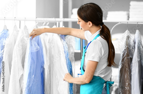 Female worker near rack wit...