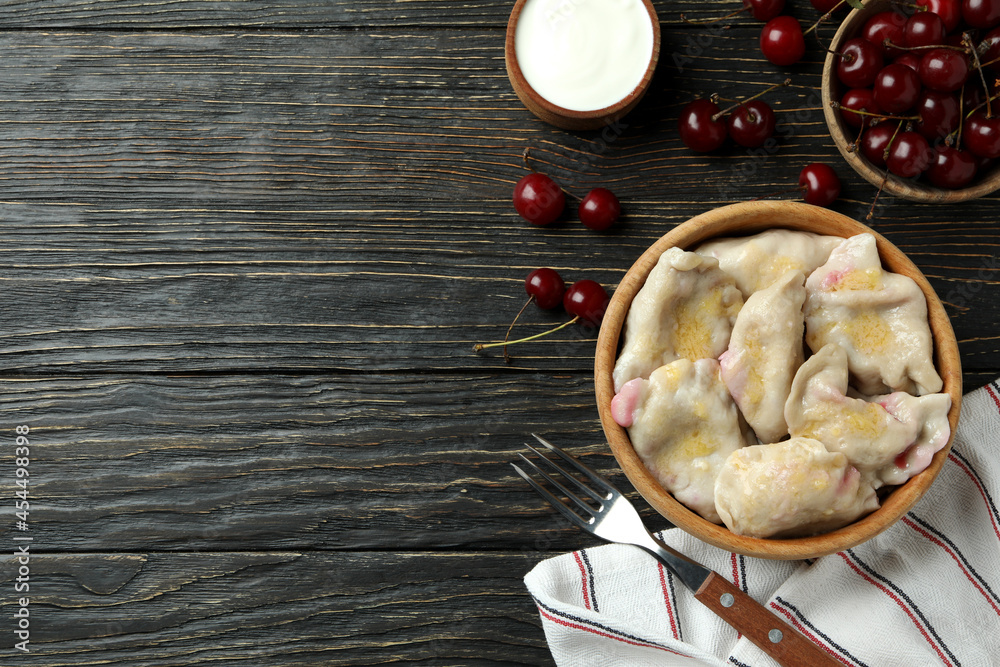 Concept of tasty food with pierogi with cherry on rustic wooden table Concept of tasty food with pierogi with cherry on rustic wooden table